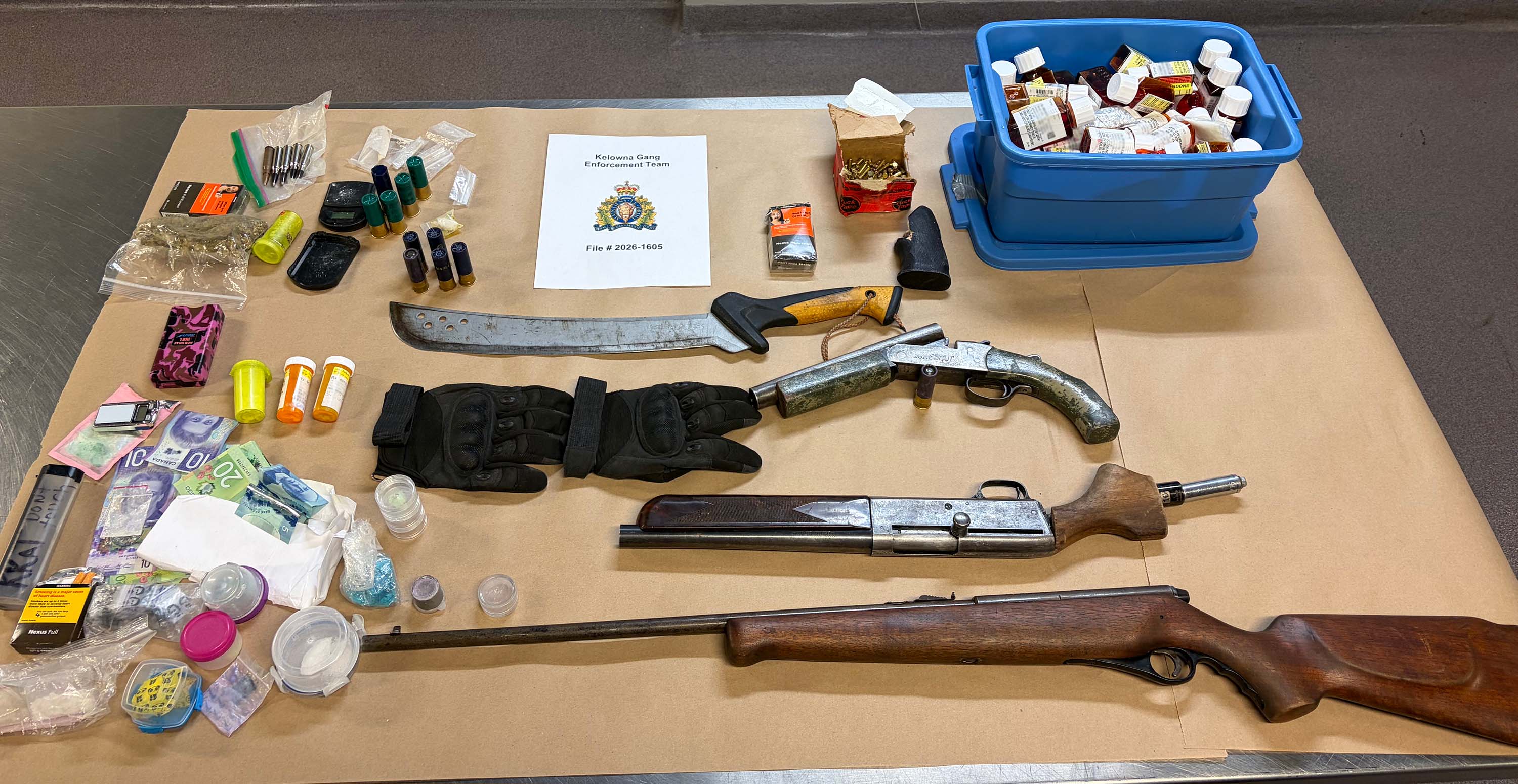 A spread of guns, drugs and cash on a table.