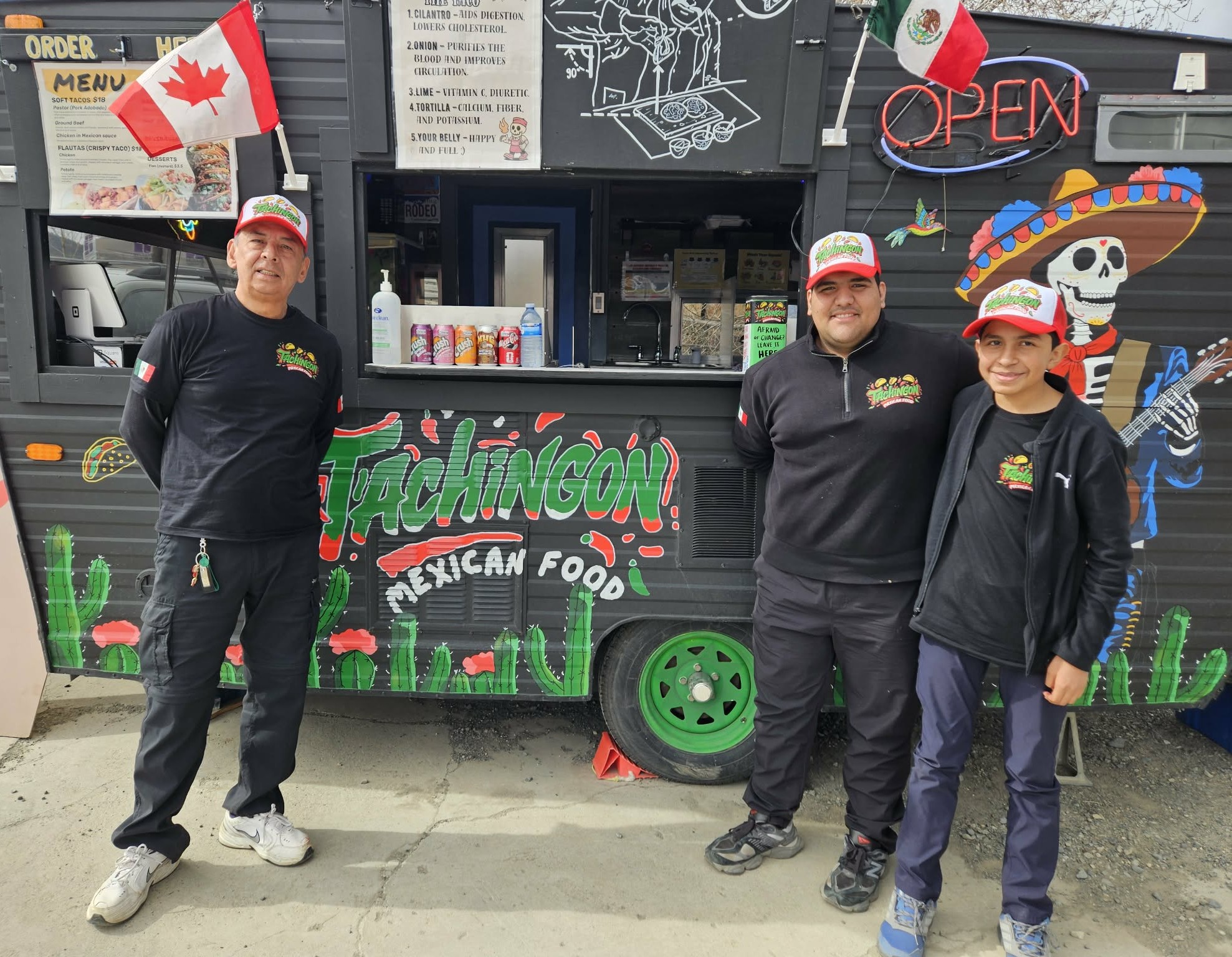 Three men stand in front of a Mexican themed food truck.