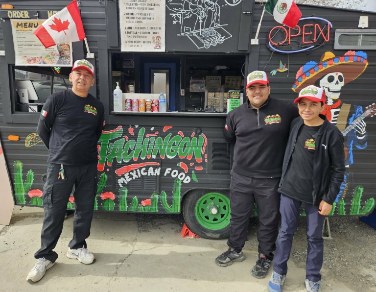 Three men stand in front of a Mexican themed food truck.