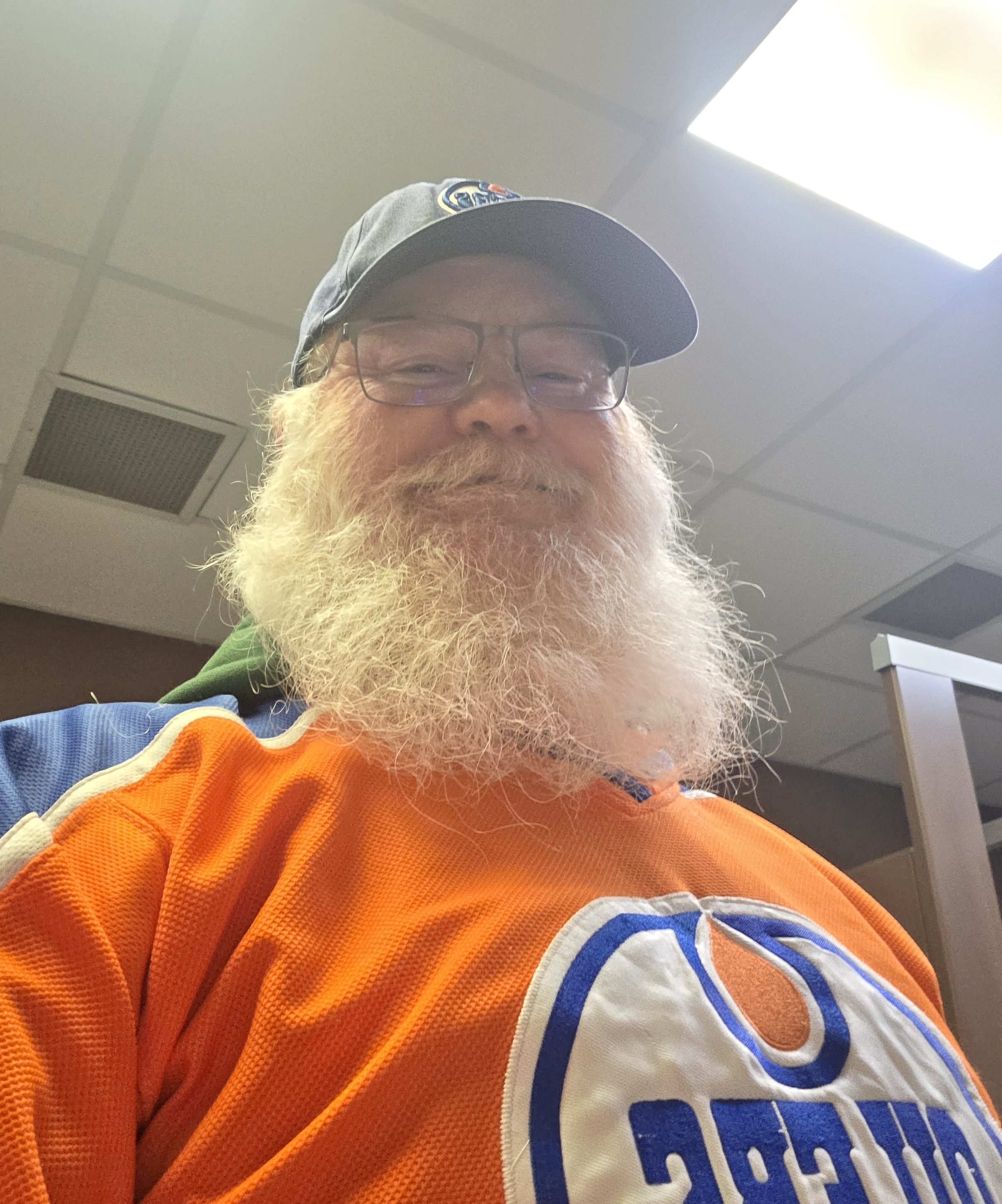 Stephen Gunning wears a basecap and an Oilers jersey.