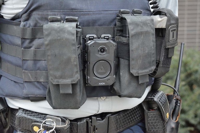 A close-up of a police officer's chest with a body camera.