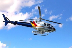 A photo of an RCMP helicopter flying on a sunny day.