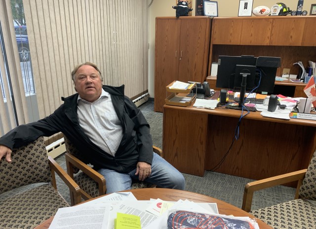 A man sits at a table in an office.