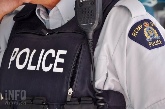 A closeup of a man wearing a police vest and and RCMP shoulder patch.