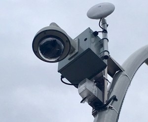 An outdoor surveillance camera is seen from below.