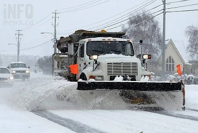 A snow plow on a city road.