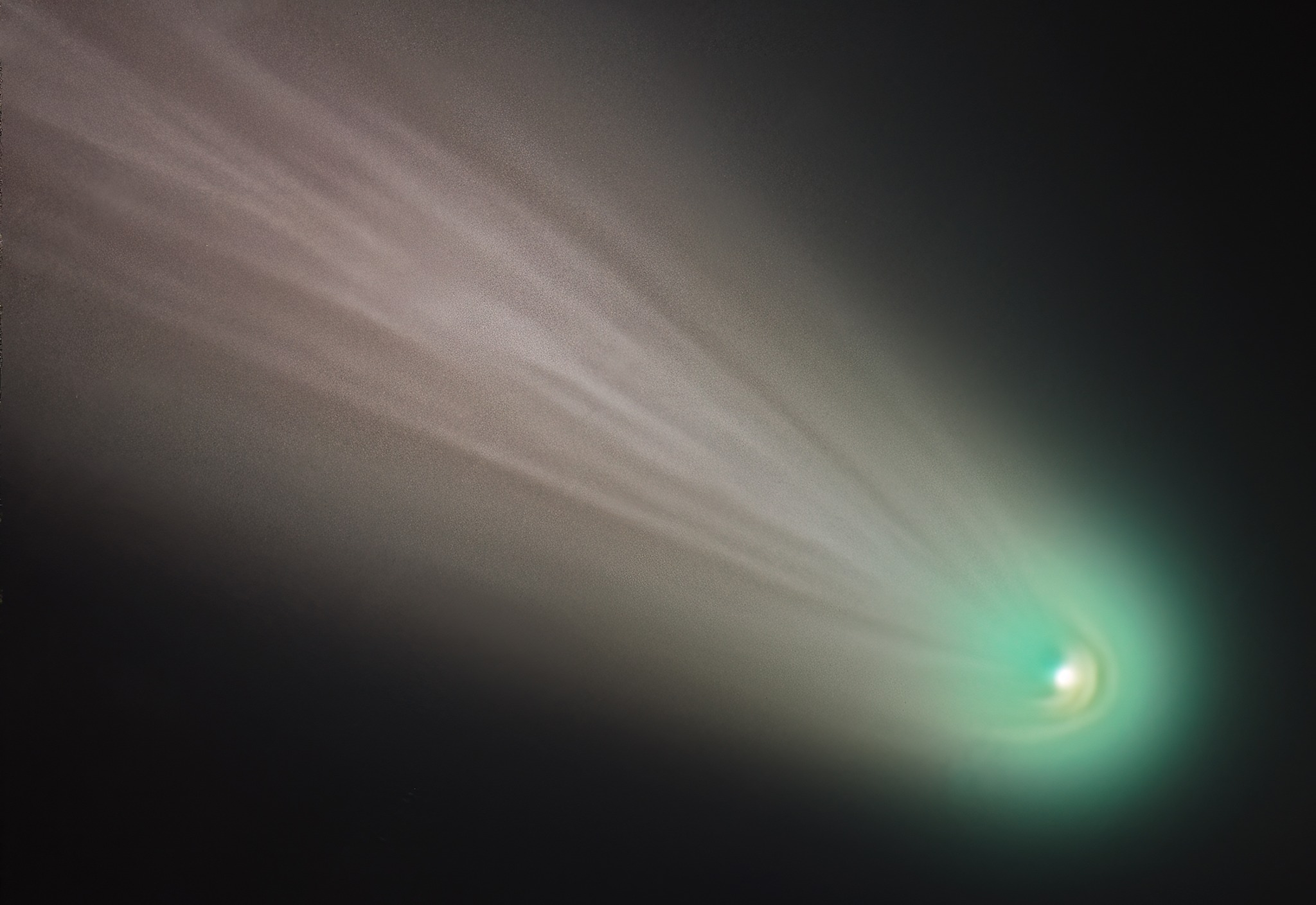 A bright green comet with a long white tail glows in a black sky.