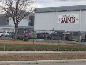 Exterior of a high school seen with multiple police vehicles in front.
