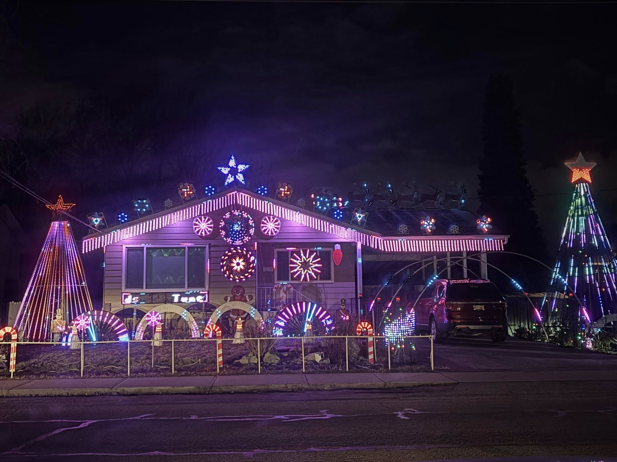 A residential house is lit up with Christmas lights and decorations.