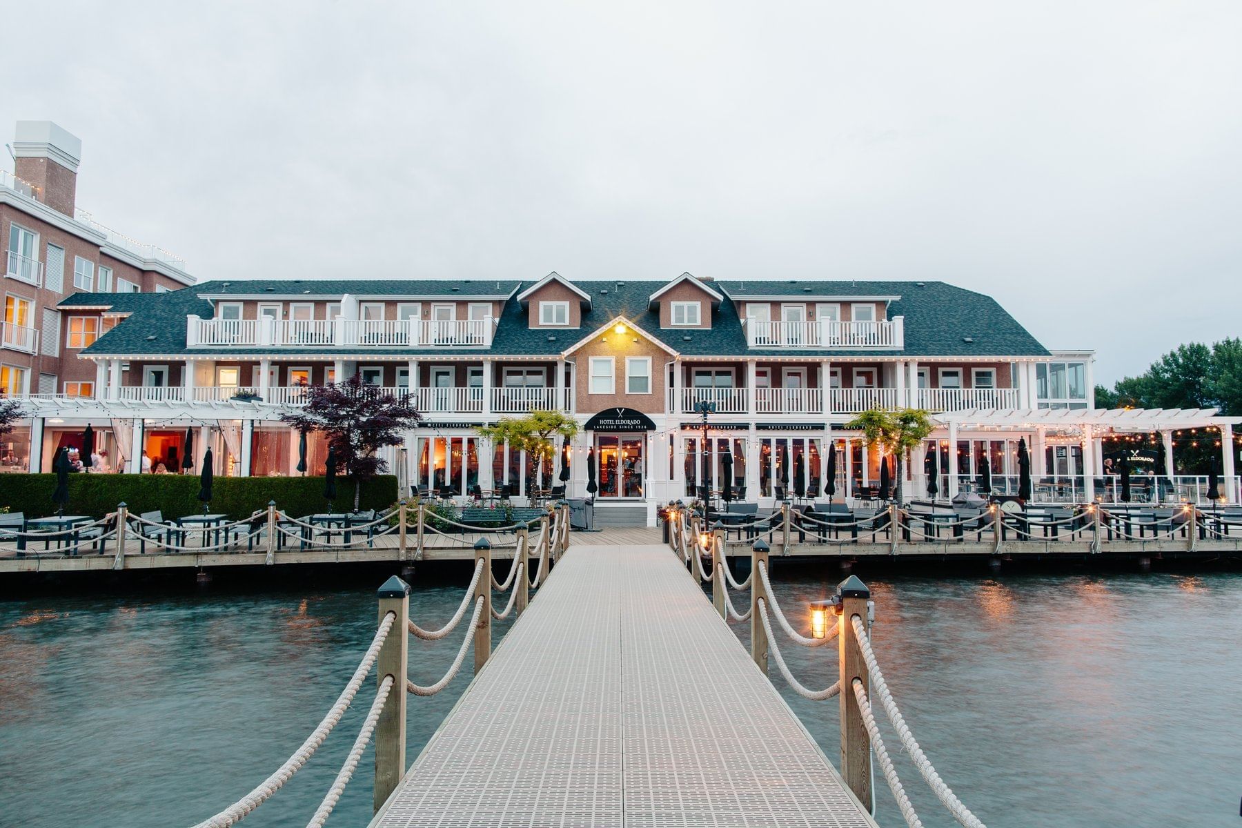 A hotel on the waterfront with a large deck and dock.