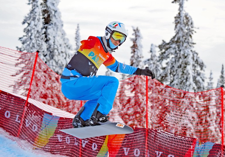 A snowboarder with one arm mid-air.
