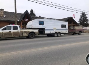 A pickup truck is connected to a trailer which is connected to a homemade trailer.
