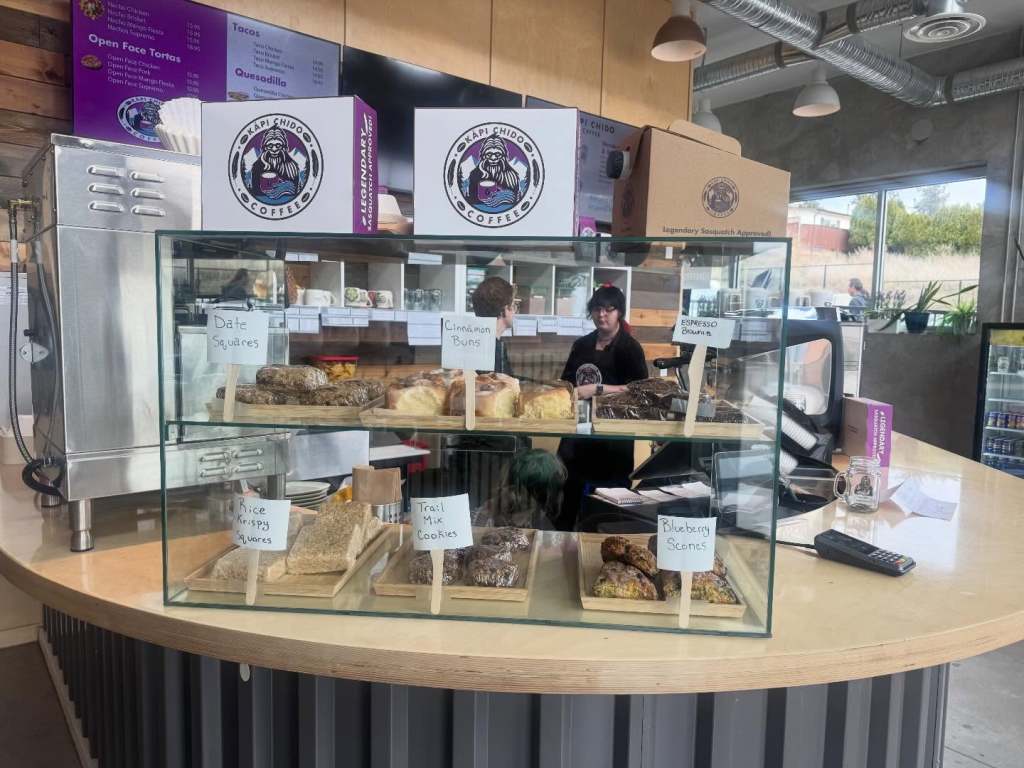 Baked goods are placed under a glass cover at a cafe.