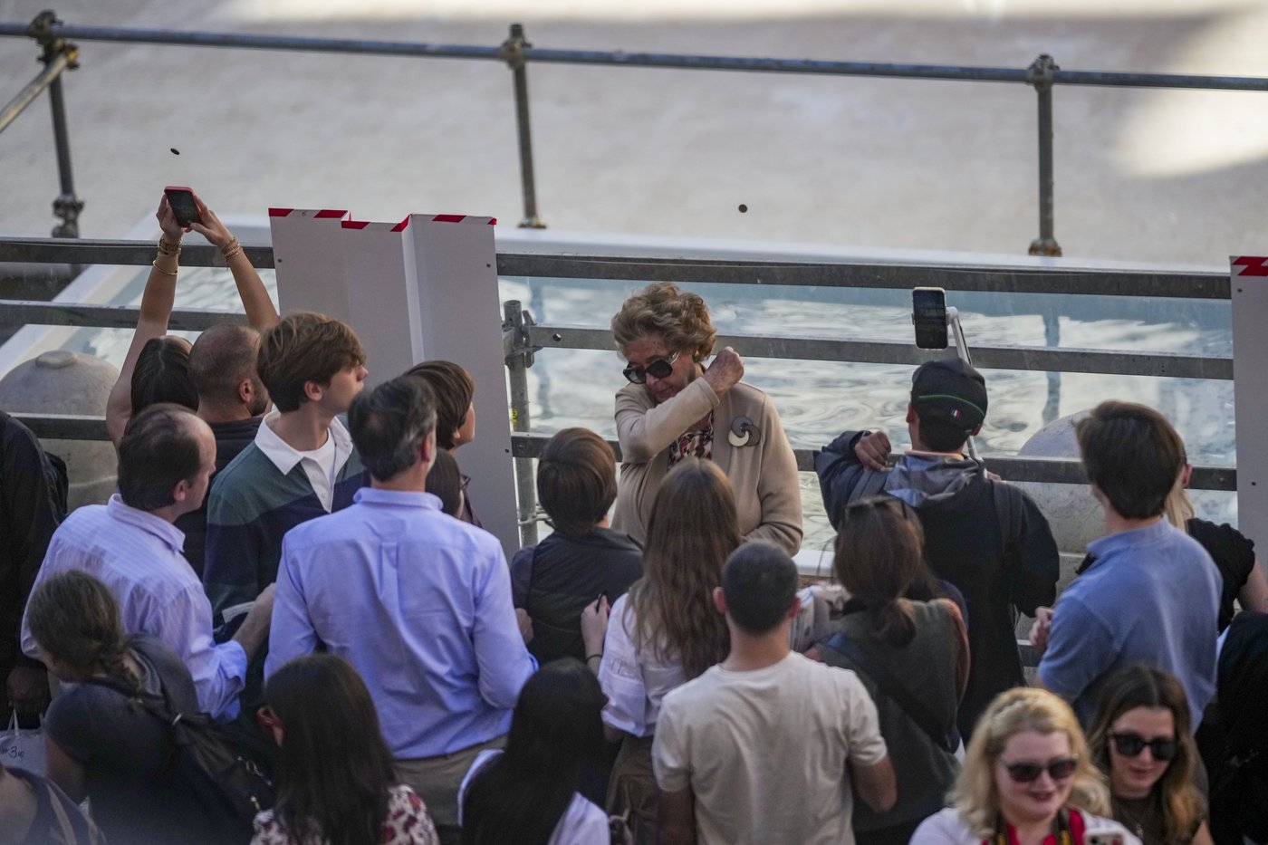 Tourists toss coins over a makeshift pool as Rome’s Trevi Fountain undergoes maintenance | iNFOnews.ca