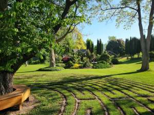 A large property has grass, trees, shrubs and flowers.
