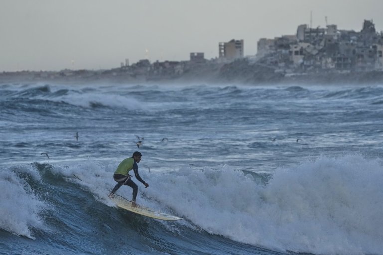 Photos show surfers riding waves along Gaza City’s damaged coastline | iNFOnews.ca
