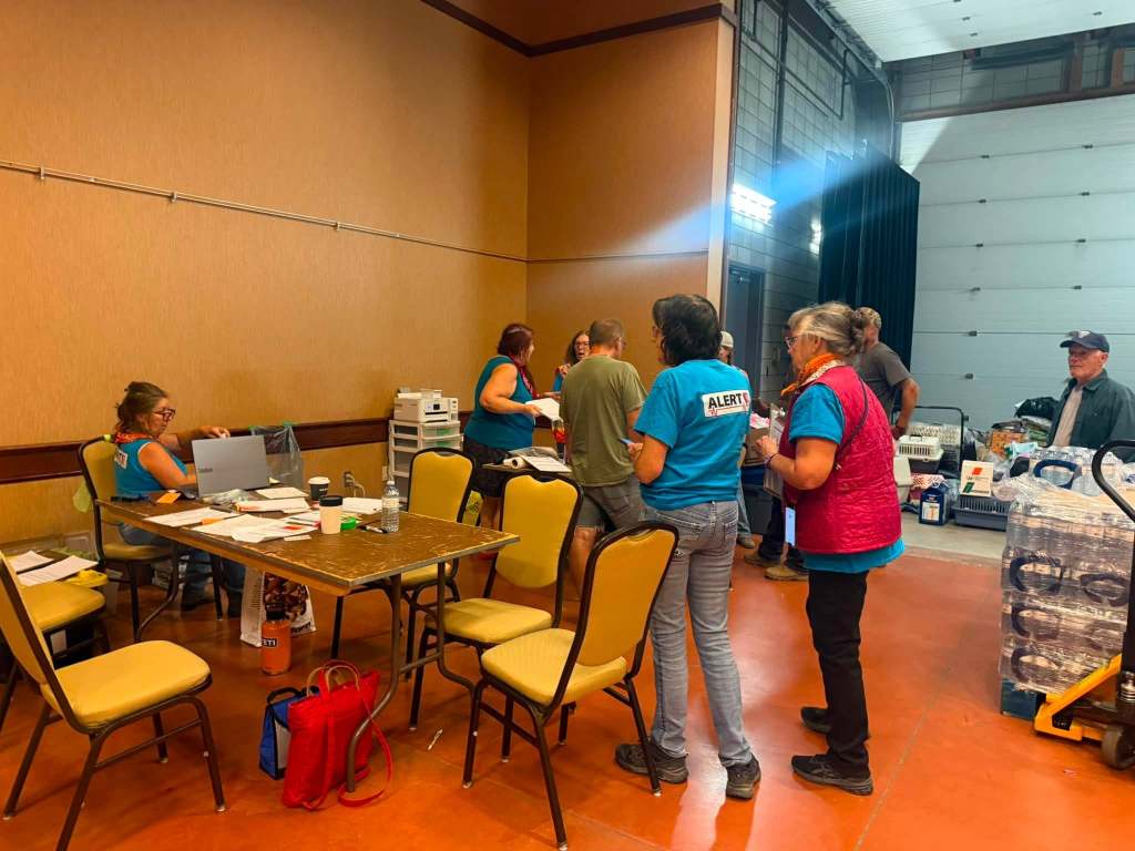 People are seen in a facility with chairs and supplies.