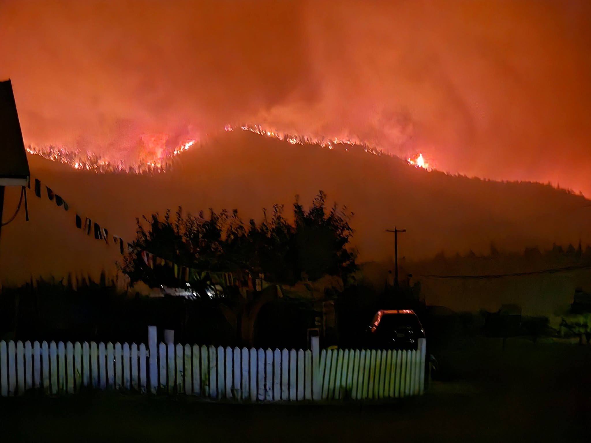 A mountain is lit up with wildfire at night.