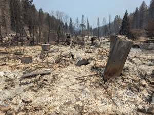 Ash and rubble are left after a wildfire destroyed a house.