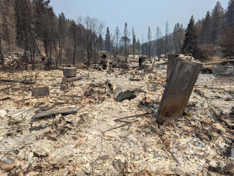 Ash and rubble are left after a wildfire destroyed a house.