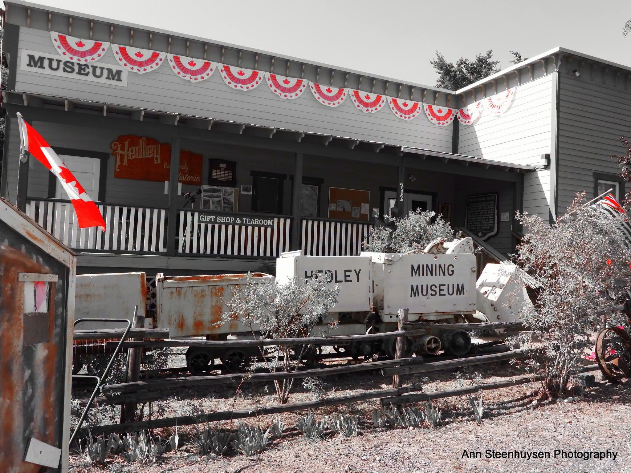 A museum has a string of old mining carts in front of it.
