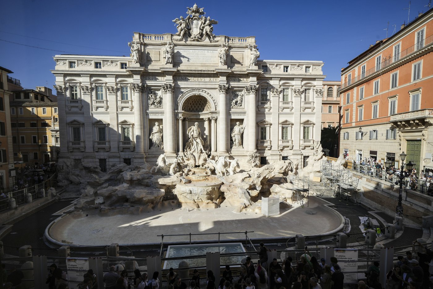 Tourists toss coins over a makeshift pool as Rome’s Trevi Fountain undergoes maintenance | iNFOnews.ca