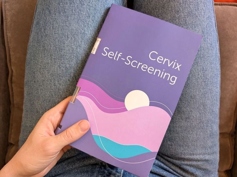A hand holds a booklet titled Cervix Self-Screening.