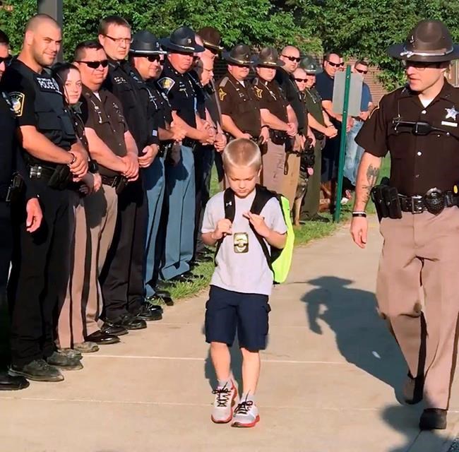 70 officers welcome slain cop's son on his return to school | iNFOnews.ca CP302080476