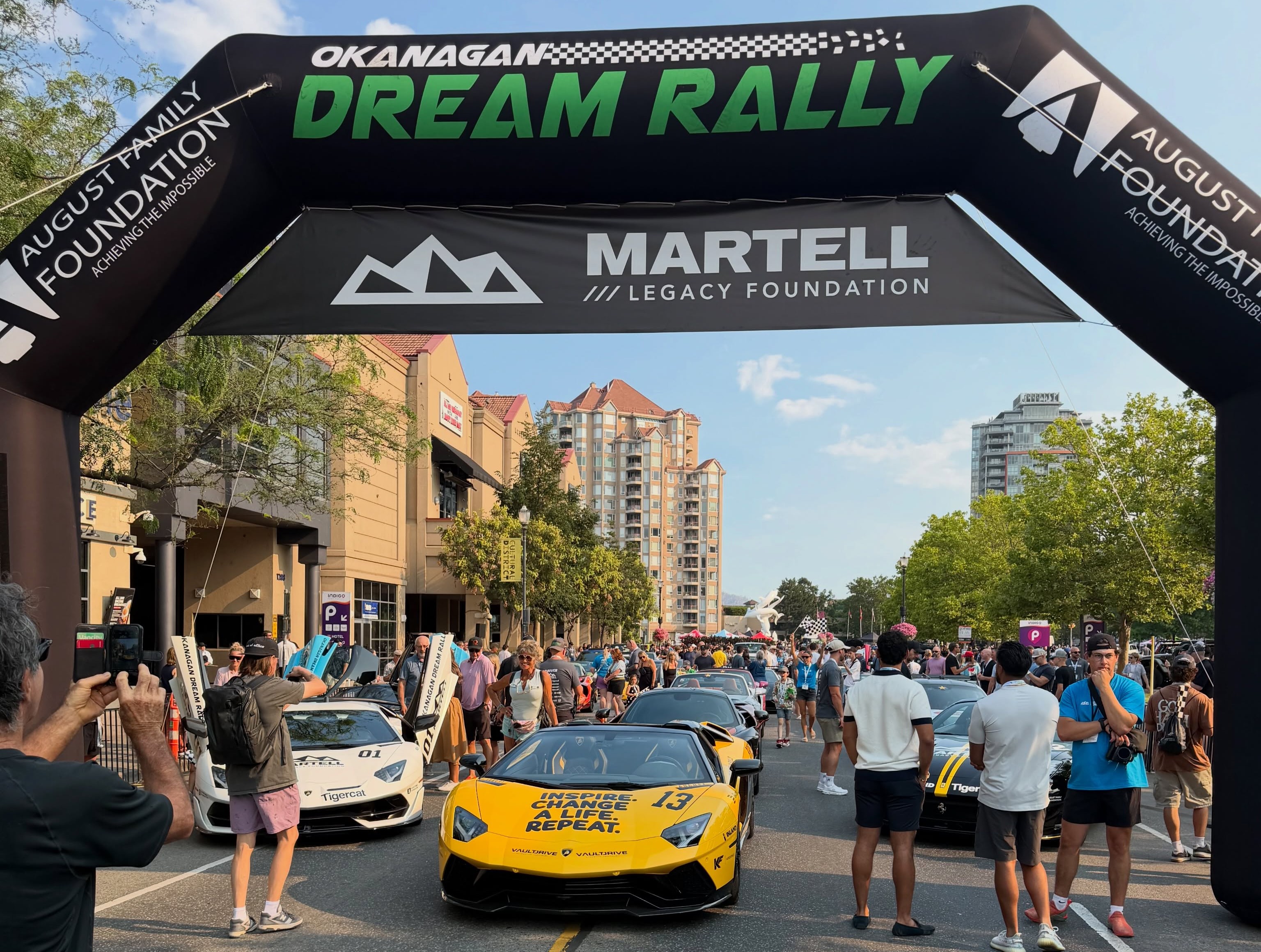 The beginning of a car parade with fancy cars is seen.