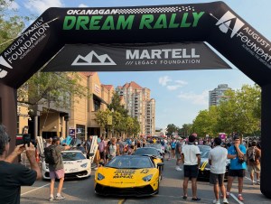 The beginning of a car parade with fancy cars is seen.