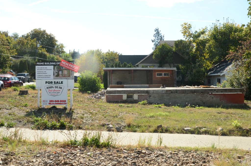 a demolished house with a for sale sign