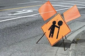 Flag people ahead sign with orange flags.