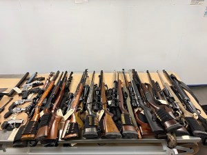 Handguns and rifles displayed on a table.