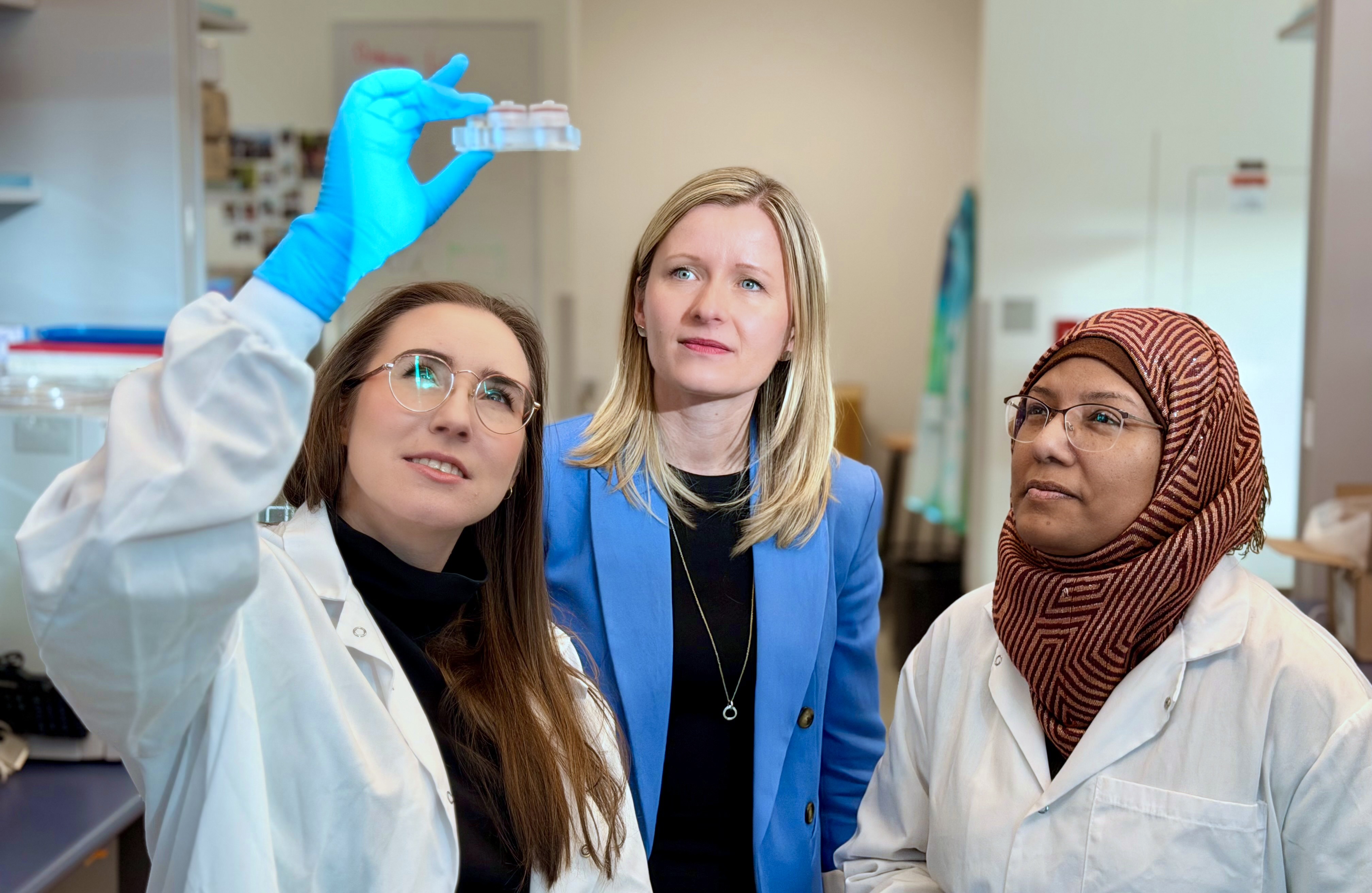Three scientists looking at a slide.