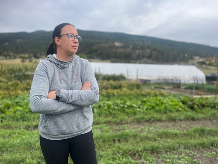 Cynthia Proudlove stands arms folded in her commerial garden.