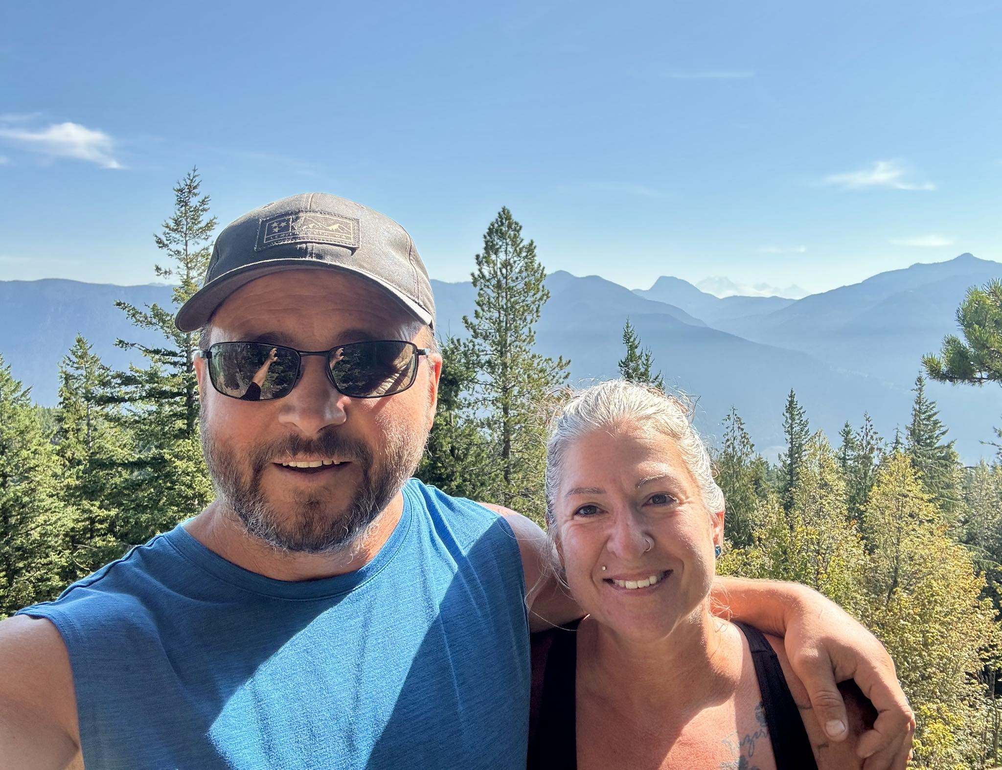 A man and woman with their arms around each other are smiling.