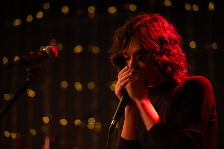 A musician playing harmonica on stage.