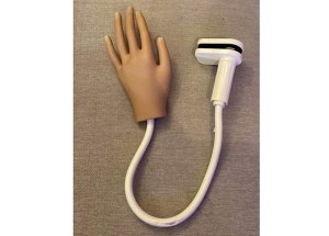 A rubber hand is attached to a cord with a clip on the end.