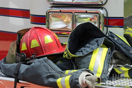 Firefighter gear is piled at the front of a fire truck.