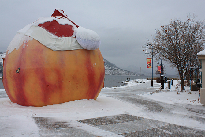 A peach concession stad with a santa hat on in the snow.