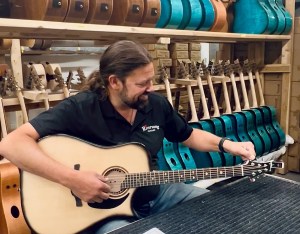 A man tunes a guitar.