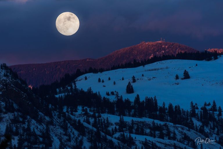 A full moon shines bright in a dusky clear sky over Kamloops.