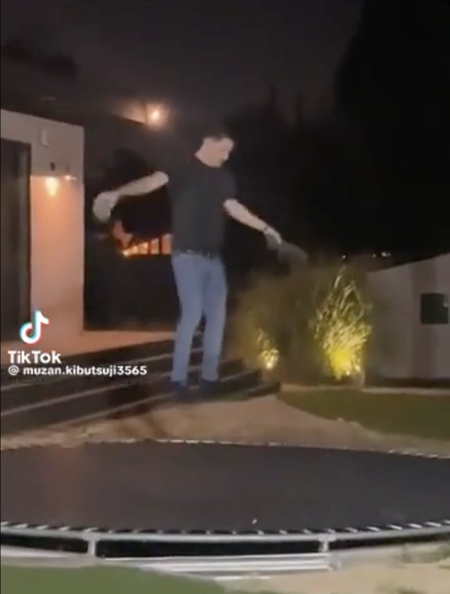 A man jumps on a trampoline.