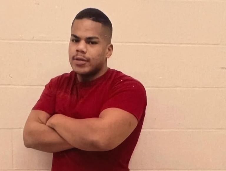 A man wears his prison clothes and folds his arms.