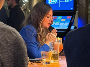 A picture of a woman praying over a Caesar cocktail.