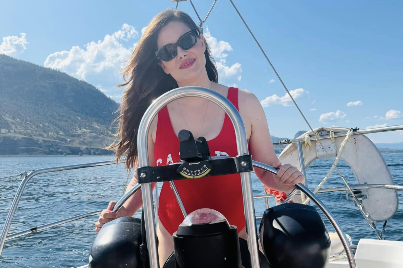 Amelia Boultbee driving a boat on the lake.