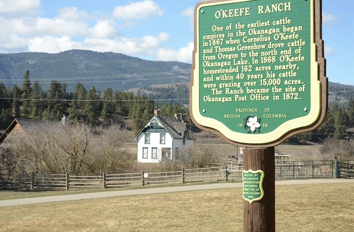 A sign with an old church in the background.