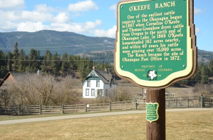 A sign with an old church in the background.
