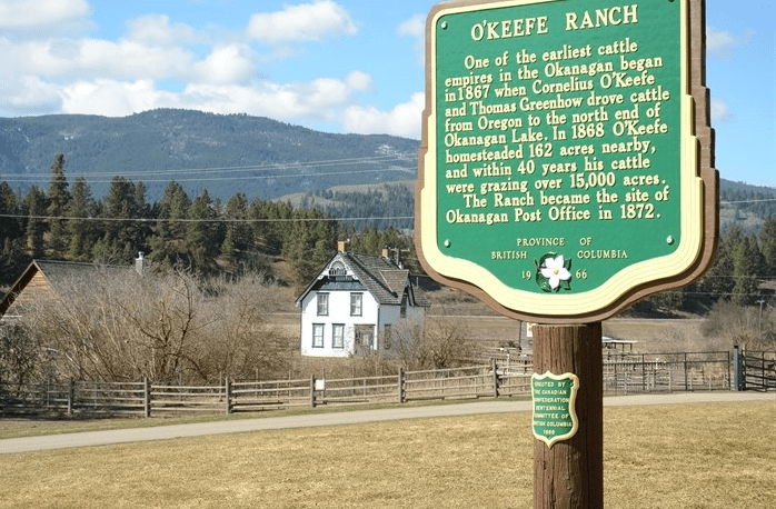 A sign with an old church in the background.
