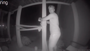 A boy with a roll of toilet paper is seen on a front porch.